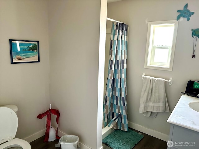 full bathroom featuring baseboards, toilet, wood finished floors, vanity, and shower / bathtub combination with curtain