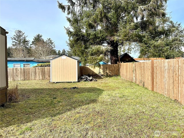 view of yard with an outbuilding, a fenced backyard, and a shed