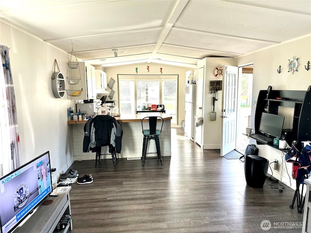 interior space with a kitchen breakfast bar, dark wood finished floors, freestanding refrigerator, a peninsula, and vaulted ceiling with beams