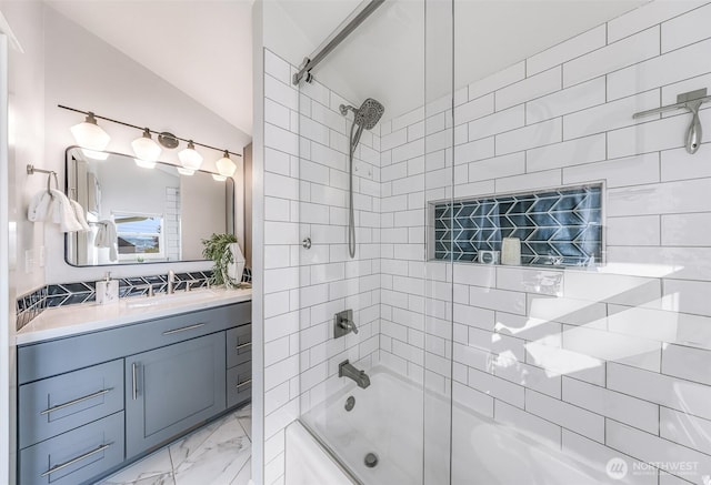 bathroom featuring vanity, vaulted ceiling, tub / shower combination, and marble finish floor