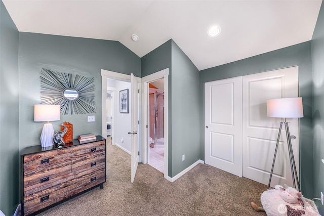 carpeted bedroom featuring ensuite bath, vaulted ceiling, and baseboards