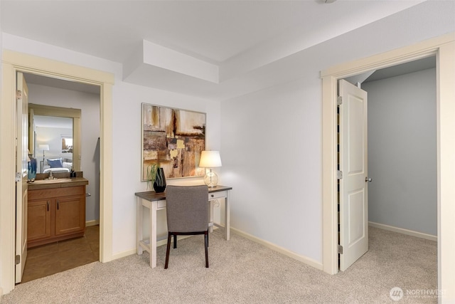 office area featuring light colored carpet and baseboards