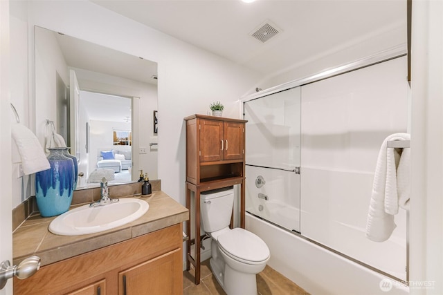 bathroom with visible vents, bath / shower combo with glass door, toilet, vanity, and ensuite bath