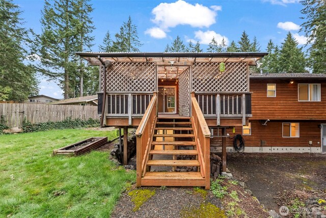 rear view of property featuring stairway, a lawn, a deck, and fence