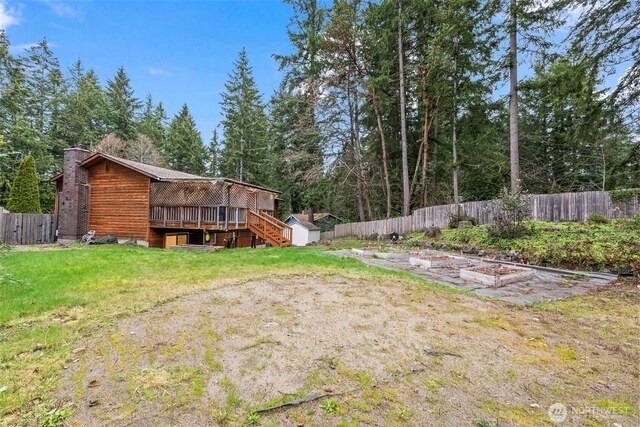 view of yard with a storage shed, a vegetable garden, and a fenced backyard