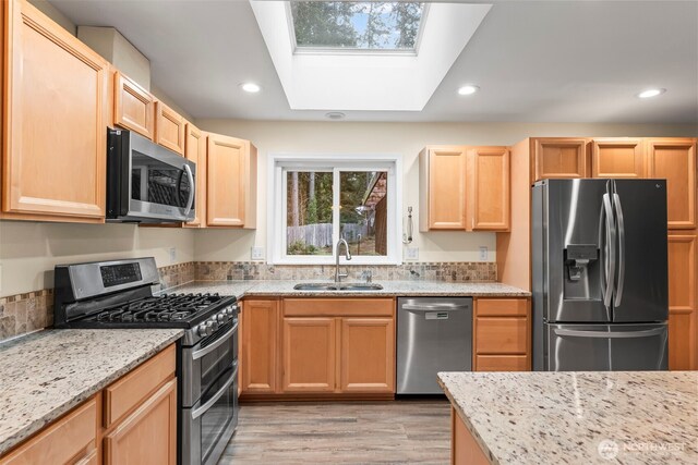 kitchen featuring a sink, recessed lighting, light brown cabinets, and stainless steel appliances