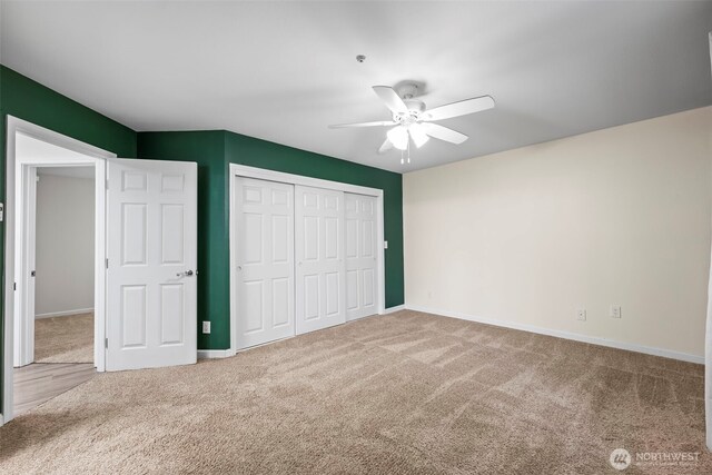 unfurnished bedroom featuring ceiling fan, carpet, a closet, and baseboards