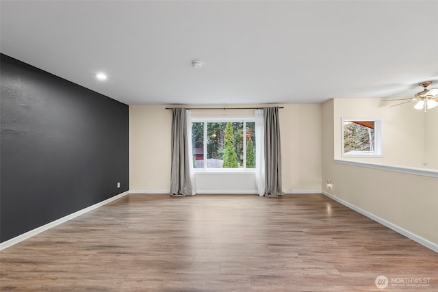 empty room featuring a ceiling fan, recessed lighting, wood finished floors, and baseboards