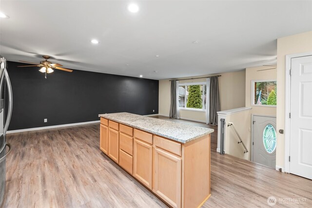 kitchen featuring light brown cabinetry, a center island, recessed lighting, light wood-style floors, and baseboards