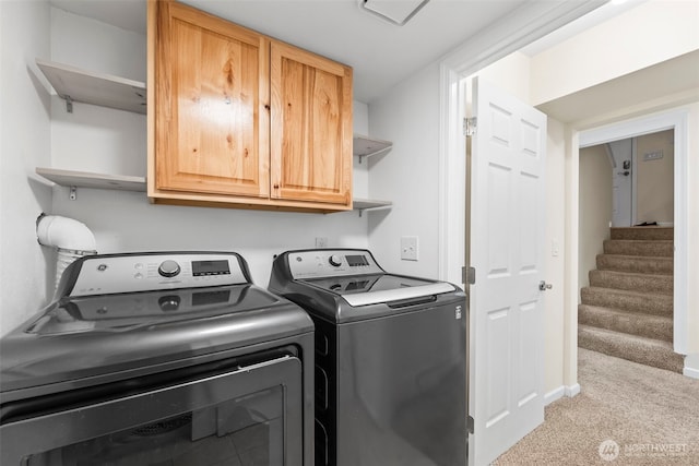 clothes washing area with washing machine and clothes dryer, cabinet space, baseboards, and carpet floors