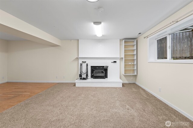 unfurnished living room with baseboards, carpet floors, and a fireplace