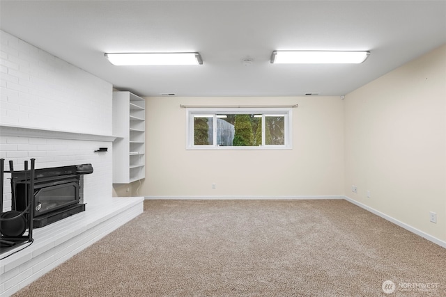 unfurnished living room with a fireplace, baseboards, and carpet floors