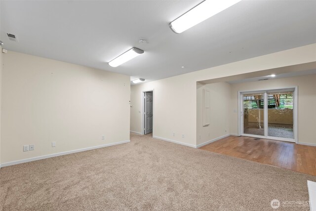 carpeted spare room with visible vents and baseboards