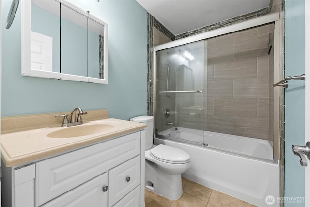 bathroom featuring vanity, tile patterned floors, toilet, and enclosed tub / shower combo