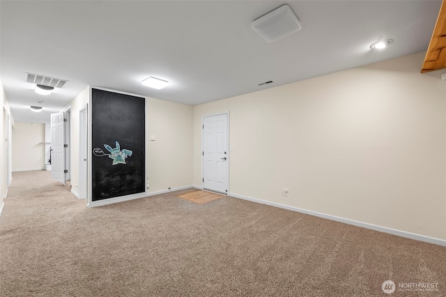 spare room featuring light colored carpet, visible vents, and baseboards