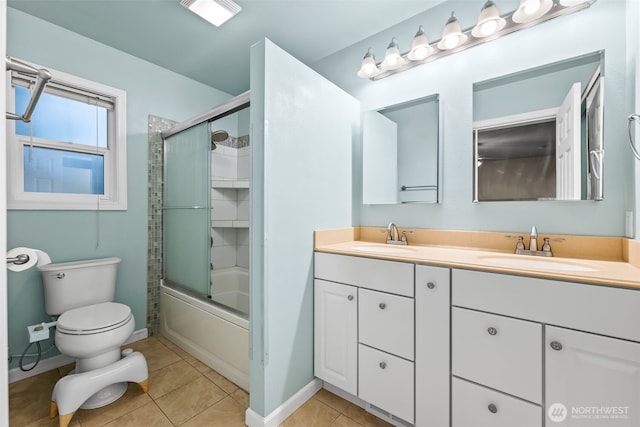 full bath featuring tile patterned floors, combined bath / shower with glass door, toilet, and a sink