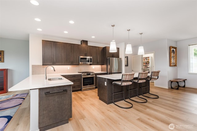 30 Sundae Dr, Sequim, WA 98382 - kitchen with a sink, dark brown cabinetry, light countertops, appliances with stainless steel finishes, and a kitchen breakfast bar