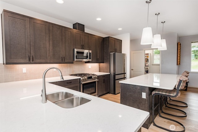 30 Sundae Dr, Sequim, WA 98382 - kitchen featuring dark brown cabinetry, a breakfast bar, decorative backsplash, appliances with stainless steel finishes, and a sink