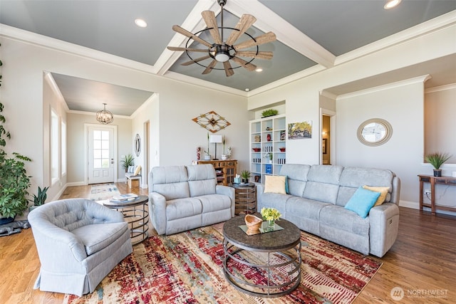 living area featuring baseboards, beam ceiling, wood finished floors, and crown molding