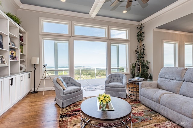 living room with crown molding, light wood-style flooring, baseboards, and ceiling fan