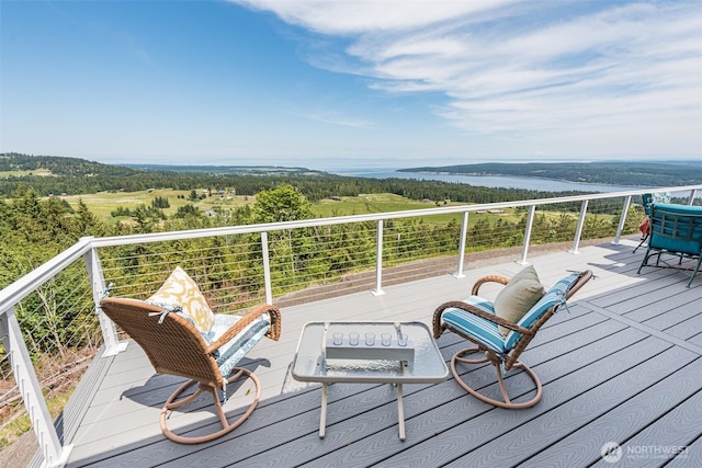 wooden terrace featuring a view of trees and a water view