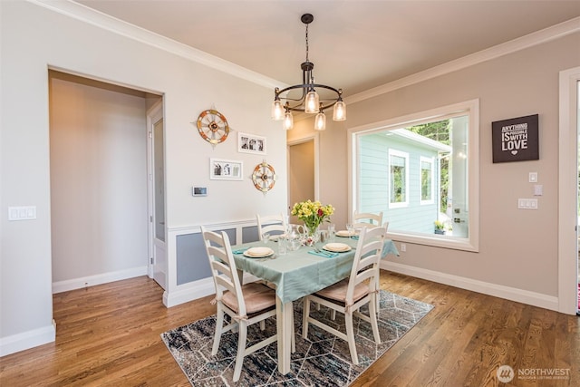 dining space featuring crown molding, light wood-style flooring, a notable chandelier, and baseboards