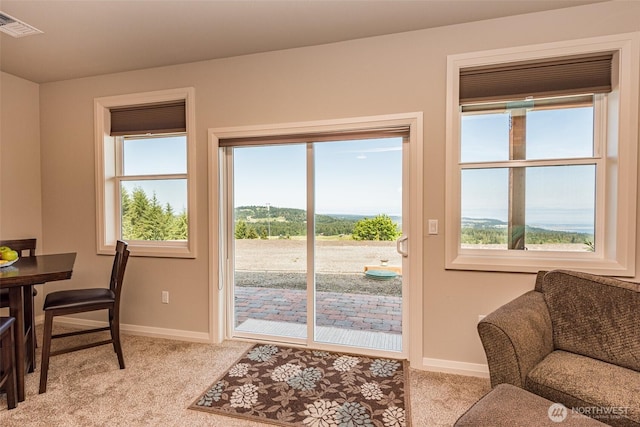 entryway with visible vents, light carpet, and baseboards