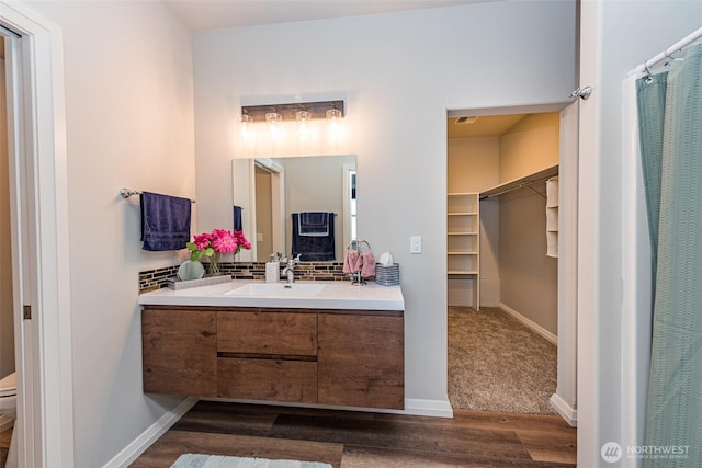 full bath featuring baseboards, toilet, wood finished floors, and vanity