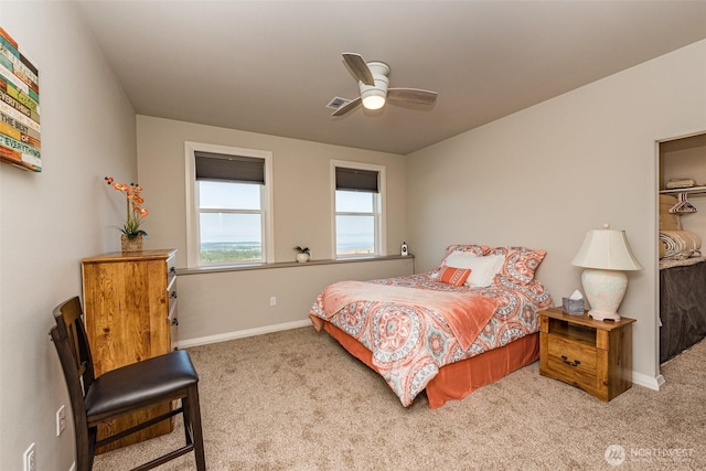 bedroom with a ceiling fan, carpet, visible vents, baseboards, and a walk in closet