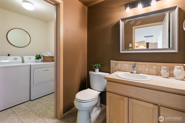 bathroom with toilet, decorative backsplash, tile patterned floors, independent washer and dryer, and vanity