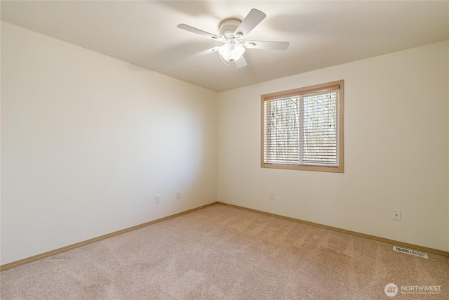 empty room with visible vents, baseboards, light colored carpet, and ceiling fan