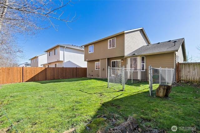 back of house featuring a lawn and a fenced backyard