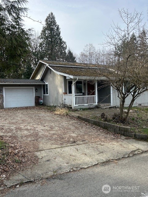 view of front facade featuring a porch, driveway, and a garage