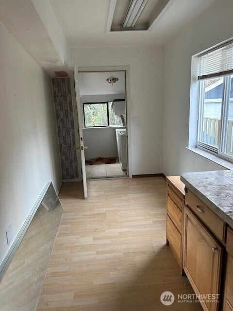 interior space featuring vanity, washer / dryer, wood finished floors, and baseboards