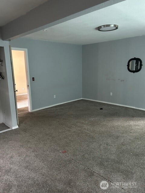 carpeted empty room with baseboards