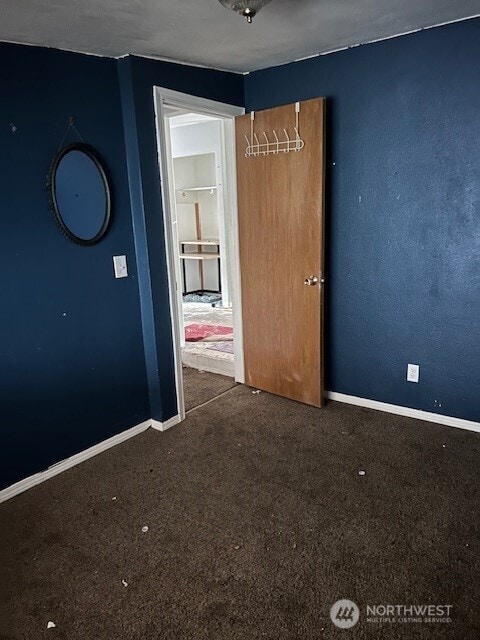 carpeted spare room featuring baseboards