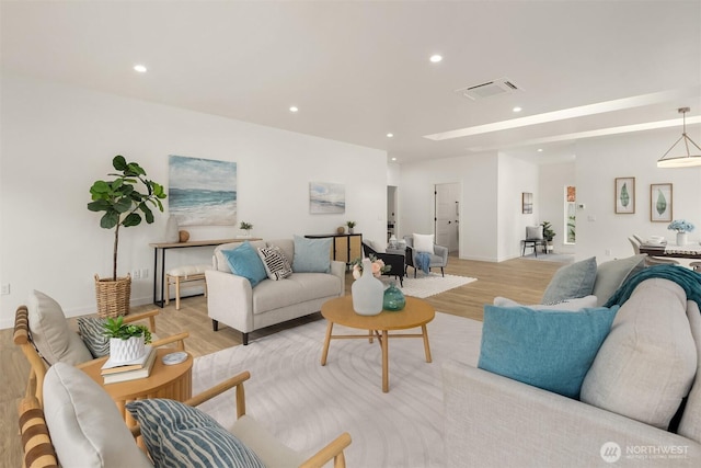 living room with recessed lighting, visible vents, and light wood-type flooring