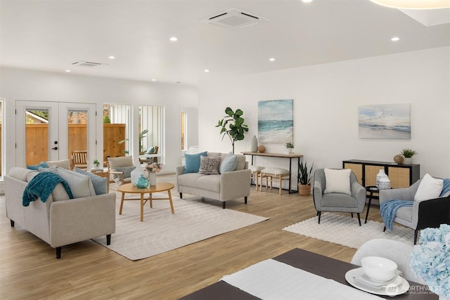 living area with recessed lighting, visible vents, french doors, and light wood finished floors