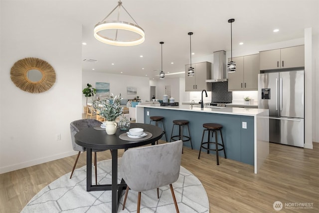 dining room featuring recessed lighting, baseboards, and light wood finished floors