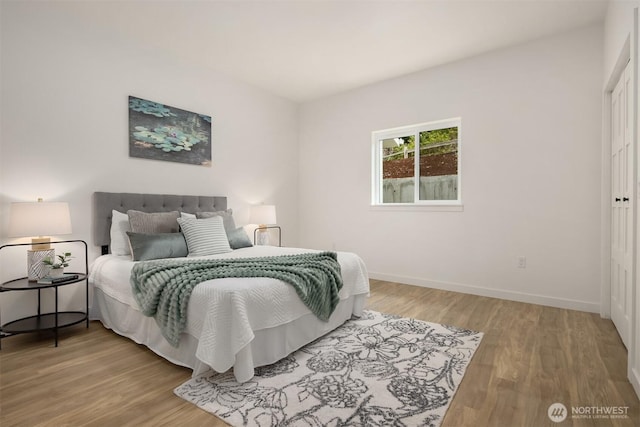 bedroom with baseboards and wood finished floors