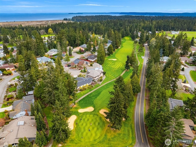 bird's eye view with a forest view, a water view, and view of golf course