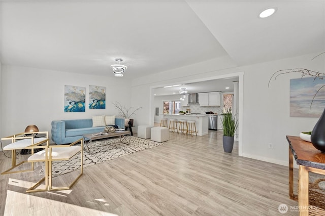 living room featuring recessed lighting, light wood-type flooring, and baseboards