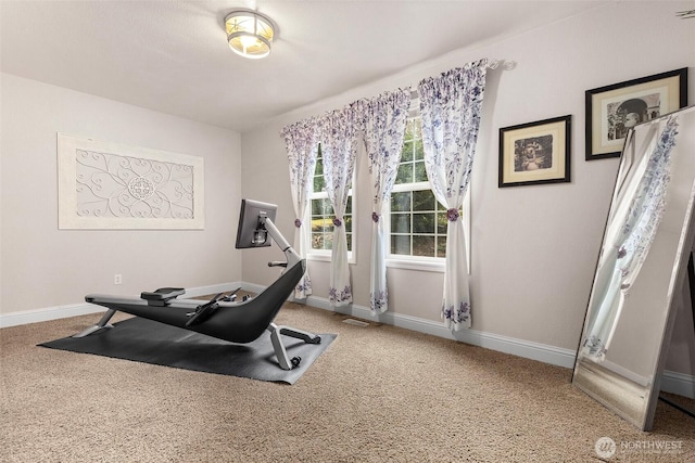 exercise area with visible vents, baseboards, and carpet