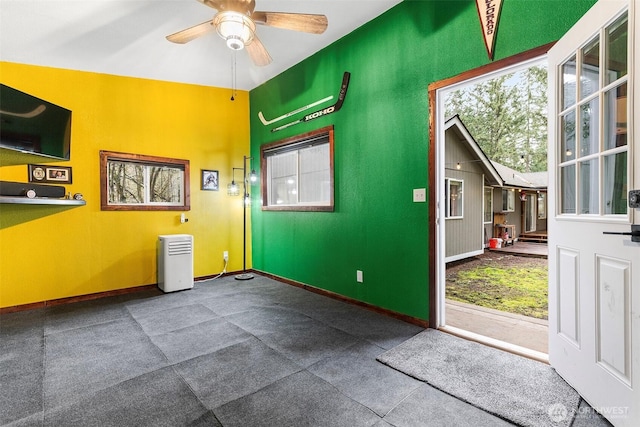 interior space featuring baseboards and a ceiling fan