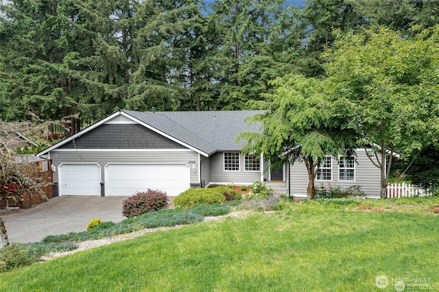 ranch-style house with a garage, concrete driveway, a front yard, and fence