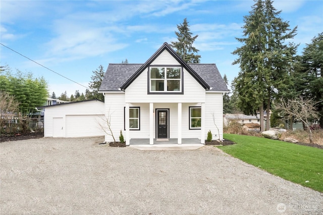 modern farmhouse style home featuring a front lawn, driveway, covered porch, a shingled roof, and a garage