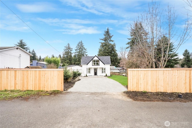 view of front of house featuring driveway and fence