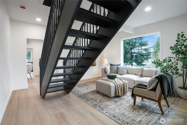 staircase with recessed lighting, wood finished floors, and baseboards