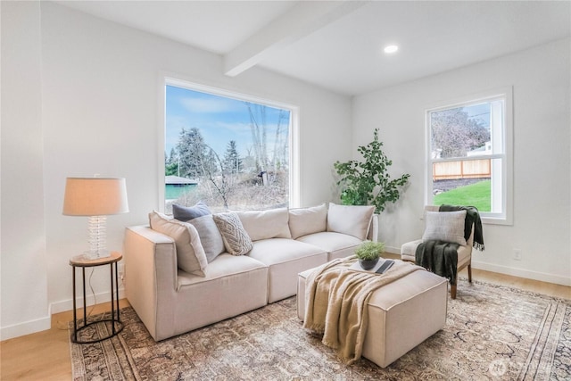 living area with light wood-type flooring, beamed ceiling, baseboards, and recessed lighting