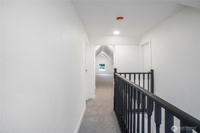 hallway with an upstairs landing, carpet flooring, and baseboards